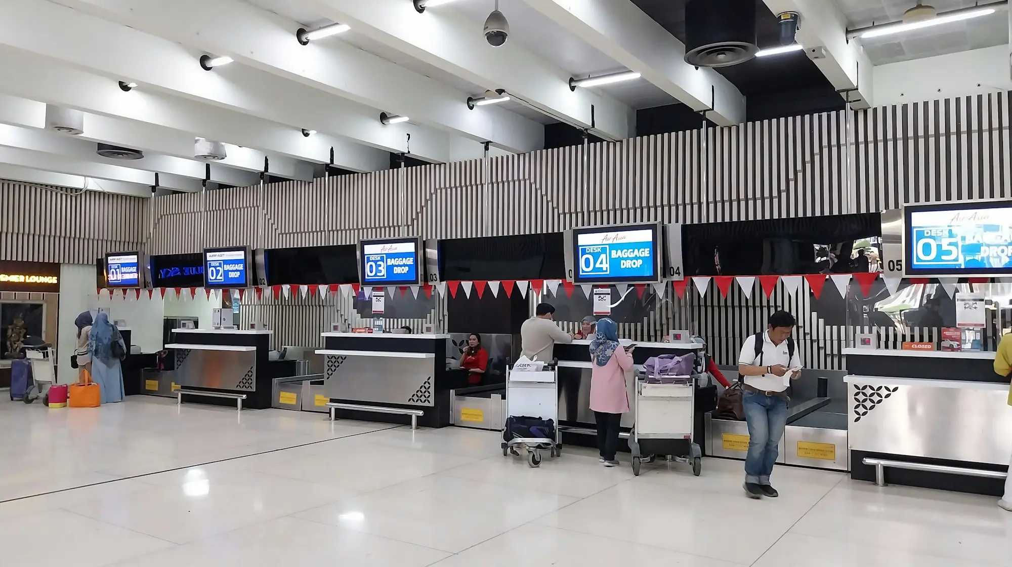 Travelers waiting at an airport gate with carry-on bags before boarding