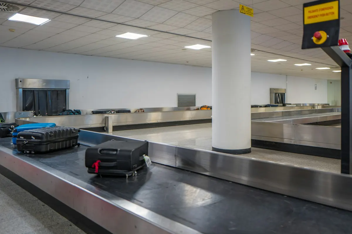 Suitcases and bags moving along a baggage claim carousel in an airport